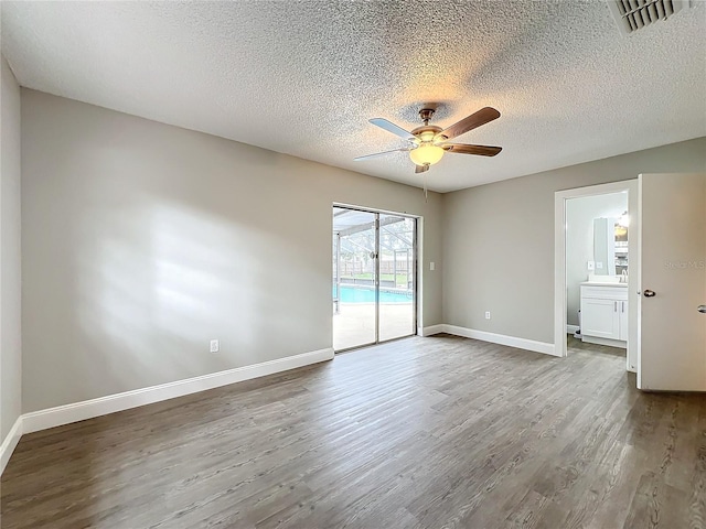 unfurnished room featuring ceiling fan, hardwood / wood-style floors, and a textured ceiling