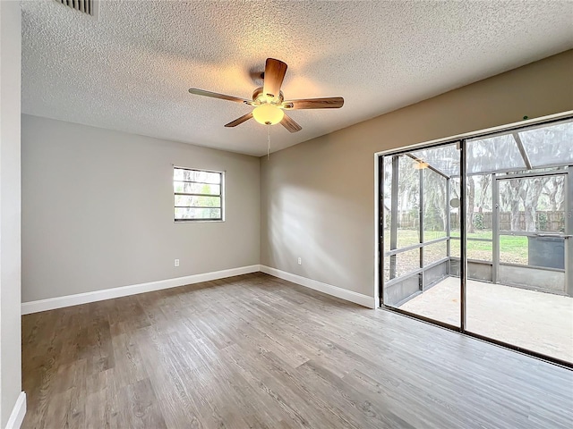 unfurnished room with hardwood / wood-style flooring, ceiling fan, and a textured ceiling