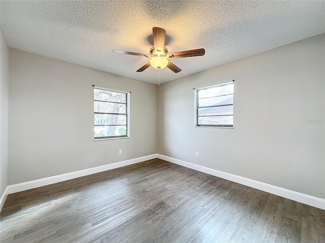 unfurnished room with a textured ceiling, ceiling fan, and dark wood-type flooring