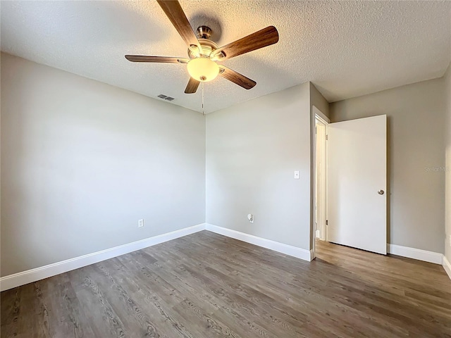 spare room featuring a textured ceiling, ceiling fan, and dark wood-type flooring