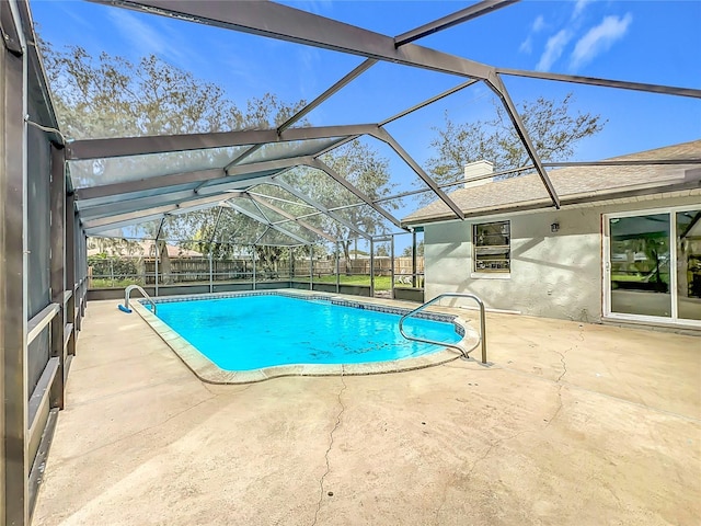 view of swimming pool featuring glass enclosure and a patio