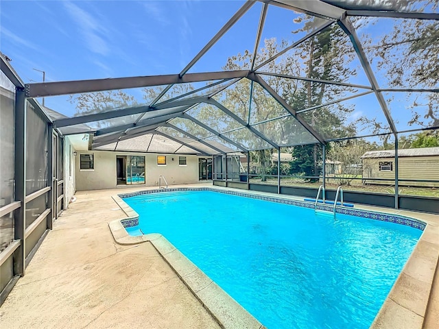 view of swimming pool featuring glass enclosure, an outbuilding, and a patio