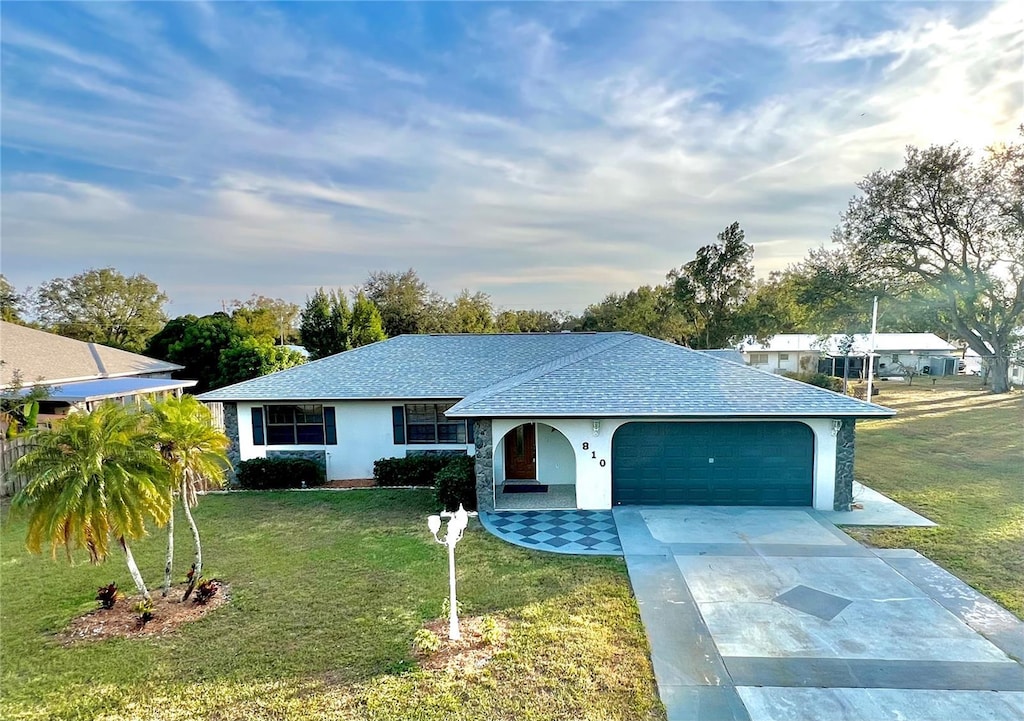 ranch-style home with a garage and a front lawn