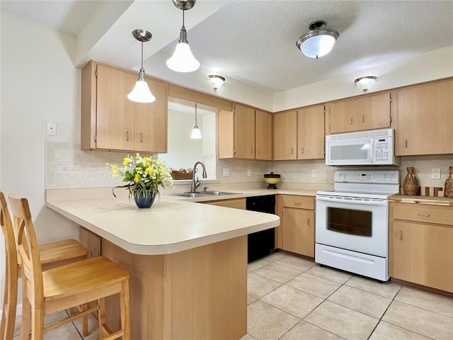 kitchen featuring sink, kitchen peninsula, decorative light fixtures, white appliances, and light brown cabinetry