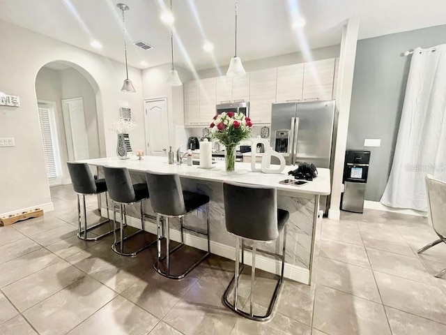 kitchen featuring pendant lighting, a large island, stainless steel appliances, and a kitchen bar