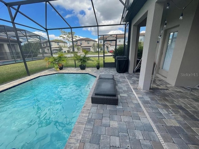 view of swimming pool featuring a patio and glass enclosure