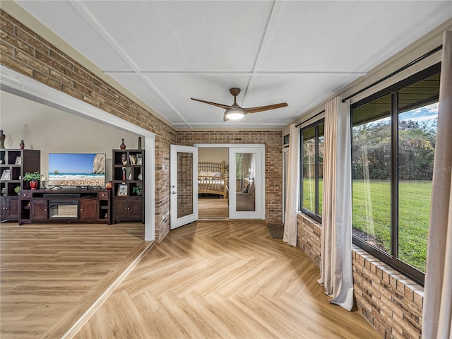 unfurnished sunroom with ceiling fan and french doors