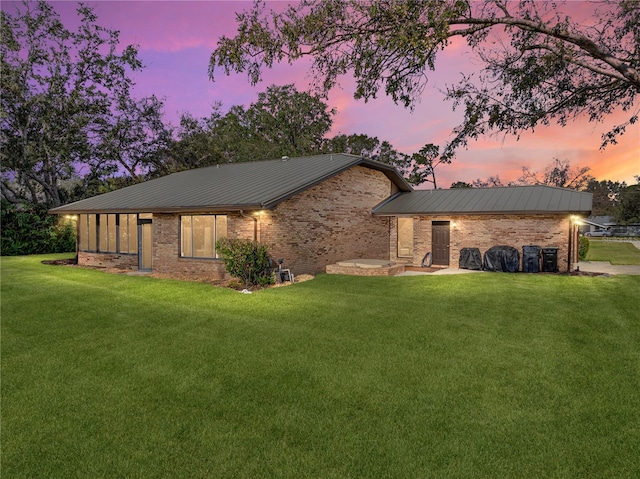 ranch-style home featuring a lawn