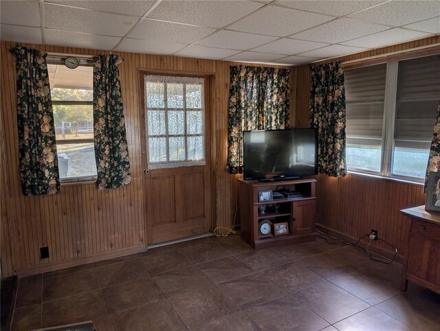 entryway with a paneled ceiling and wooden walls