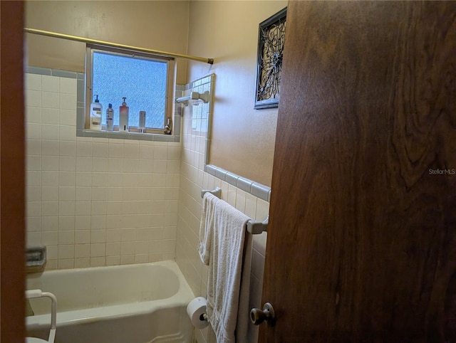 bathroom featuring tiled shower / bath and tile walls