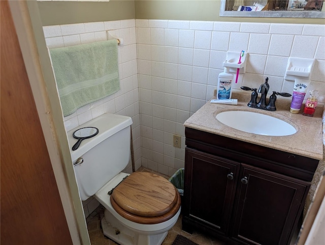 bathroom with tile patterned flooring, vanity, tile walls, and toilet