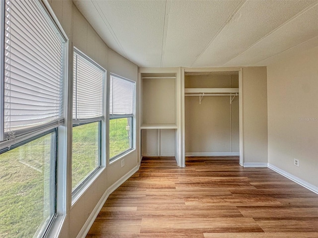 2218 Ellie Rd Unit 1, Auburndale, FL 33823 - unfurnished bedroom featuring wood finished floors, a textured ceiling, a closet, and baseboards