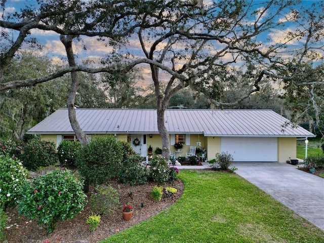 ranch-style house featuring a garage and a lawn