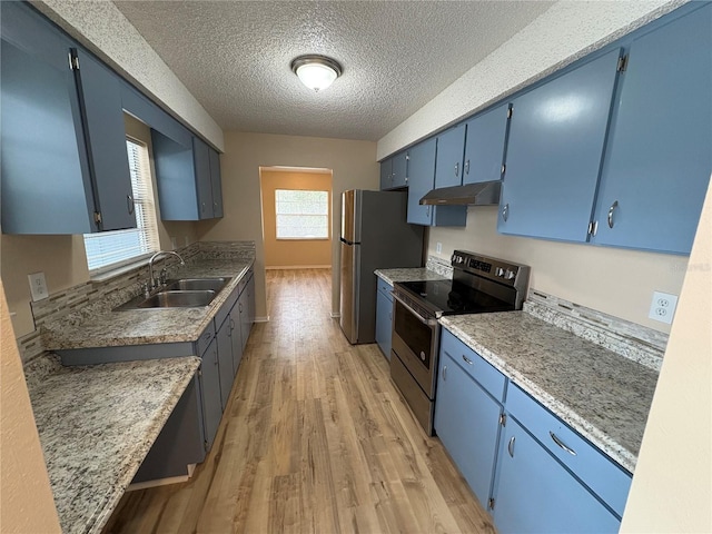 kitchen featuring blue cabinets, sink, a textured ceiling, light wood-type flooring, and appliances with stainless steel finishes