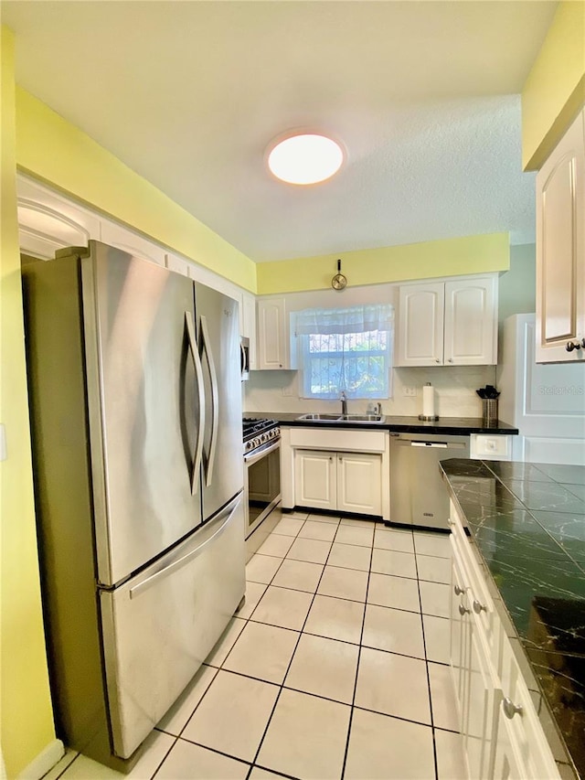 kitchen featuring white cabinetry, light tile patterned floors, stainless steel appliances, and sink