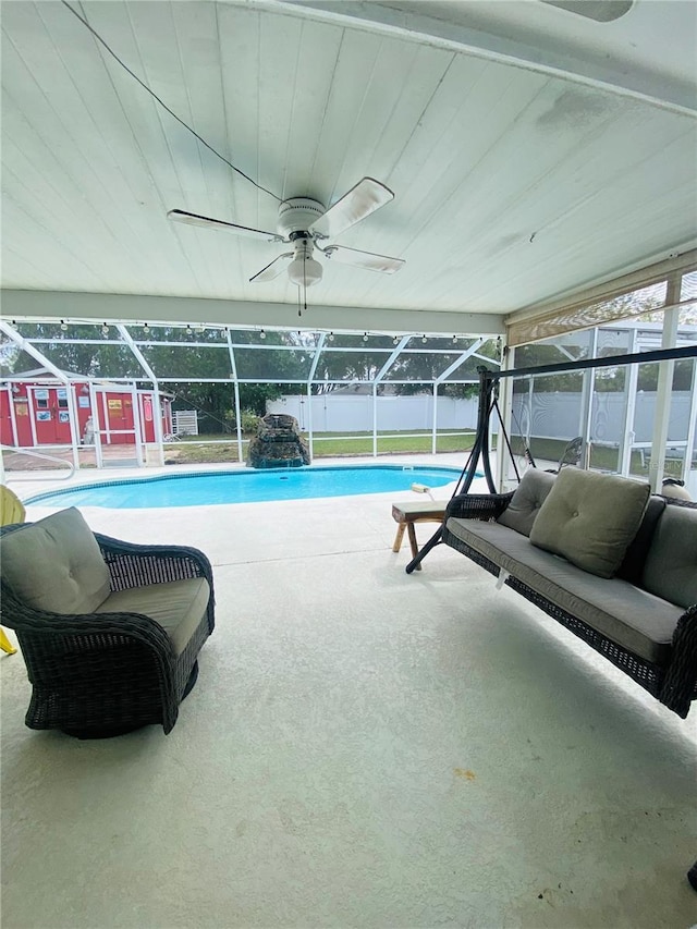 view of pool featuring ceiling fan, a patio, and glass enclosure