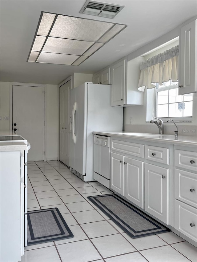kitchen with light countertops, dishwasher, visible vents, and white cabinetry