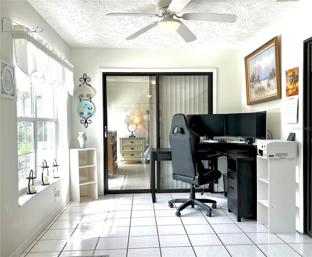 home office with light tile patterned floors, baseboards, and a textured ceiling