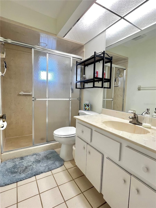full bath featuring a stall shower, tile patterned flooring, vanity, and toilet