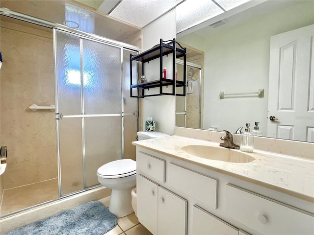 bathroom featuring visible vents, toilet, vanity, a shower stall, and tile patterned floors