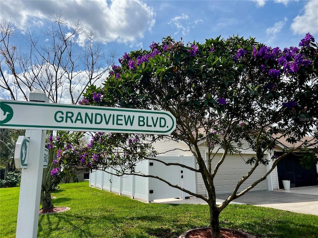 community sign with a garage and a lawn