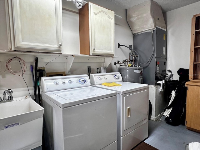 washroom featuring washing machine and dryer, cabinet space, a sink, and electric water heater