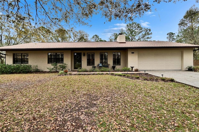 single story home featuring a garage, driveway, a chimney, a front yard, and stucco siding