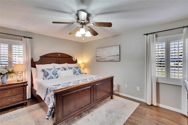 bedroom featuring wood finished floors, a ceiling fan, and baseboards