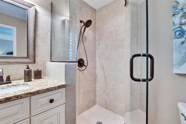 bathroom with a stall shower and vanity