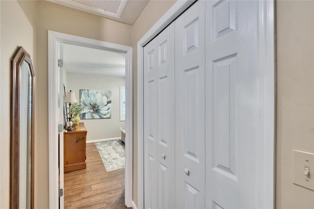 hall featuring light wood-type flooring and baseboards