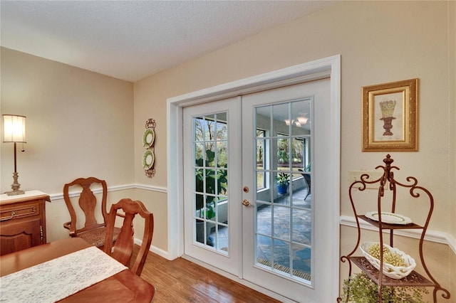 entryway featuring light wood-style floors, a textured ceiling, and french doors