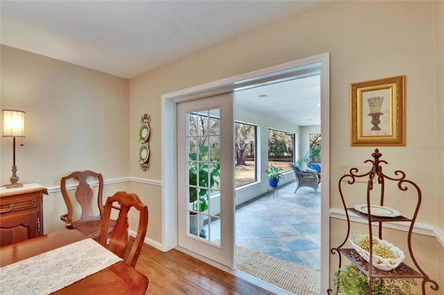 doorway to outside with light wood-type flooring and baseboards