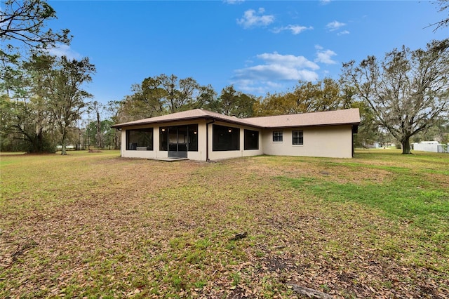 rear view of property with a sunroom and a yard