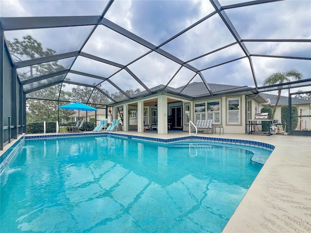 outdoor pool with a patio area and glass enclosure