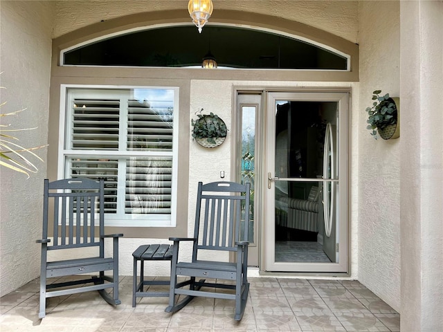 doorway to property featuring stucco siding