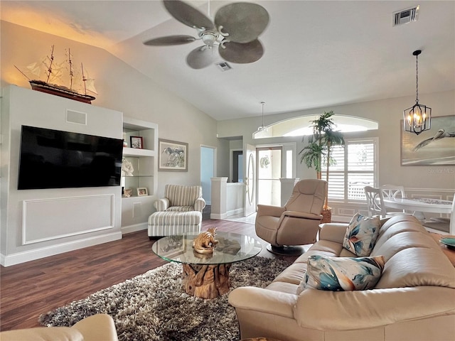 living area with built in shelves, visible vents, vaulted ceiling, and wood finished floors