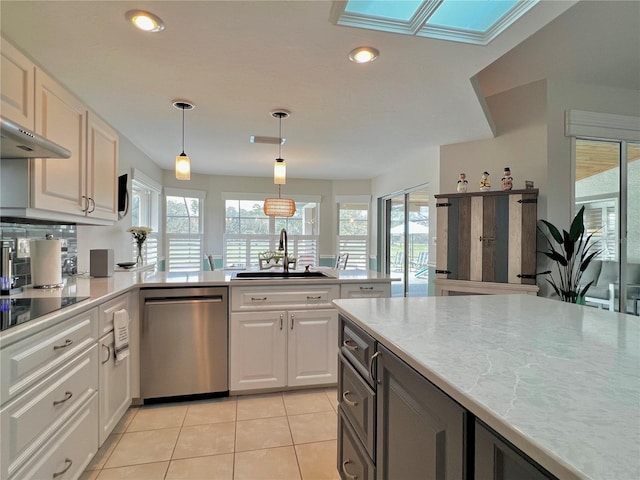 kitchen featuring black electric stovetop, stainless steel dishwasher, a sink, and a wealth of natural light