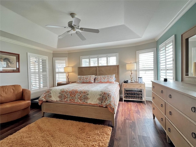 bedroom featuring ornamental molding, a tray ceiling, multiple windows, and wood finished floors