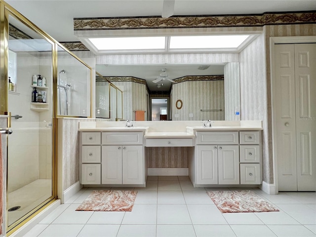 full bath with double vanity, wallpapered walls, tile patterned floors, and a stall shower