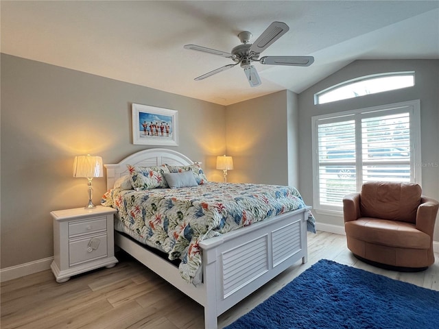 bedroom with lofted ceiling, a ceiling fan, light wood-style flooring, and baseboards