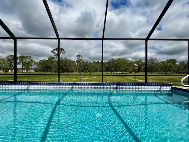 pool with a lanai and a lawn