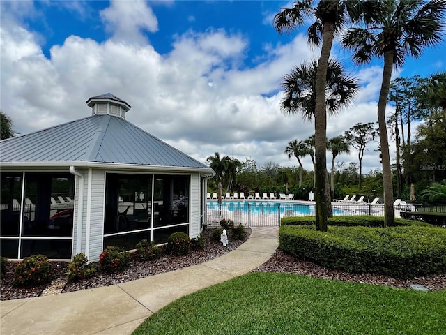 pool featuring a sunroom and fence