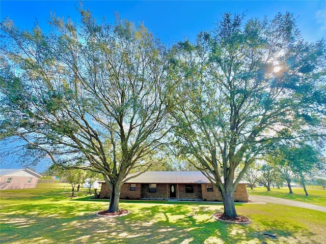 ranch-style home featuring brick siding and a front yard