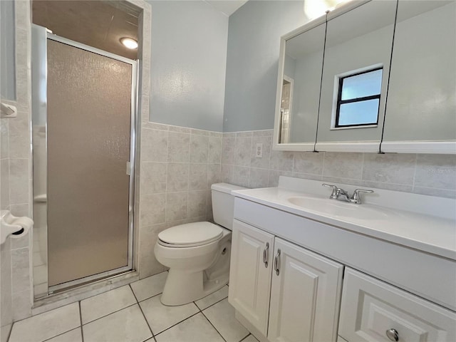 bathroom featuring vanity, a stall shower, tile patterned flooring, and tile walls