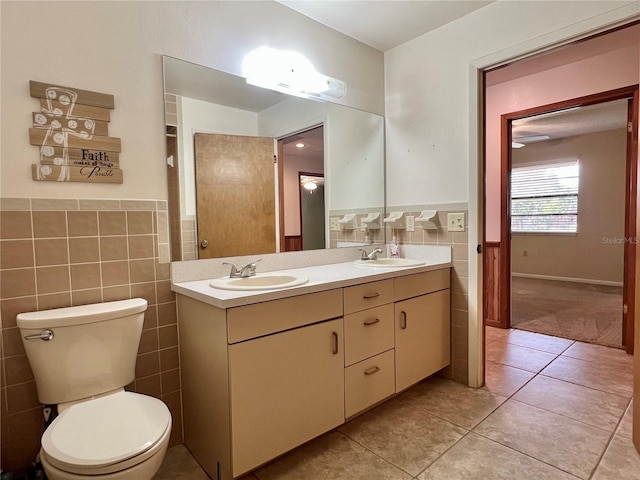 full bath featuring toilet, tile patterned flooring, a sink, and tile walls