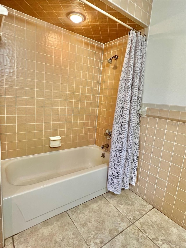 bathroom featuring shower / bathtub combination with curtain, tile walls, and tile patterned floors