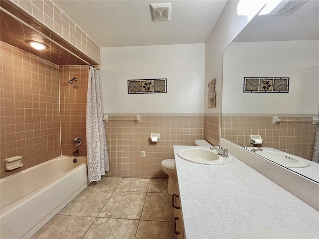 bathroom with toilet, visible vents, tile walls, and tile patterned floors