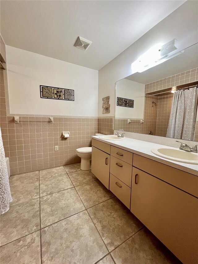 full bath featuring tile walls, visible vents, and a sink