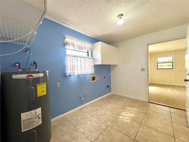 clothes washing area with water heater, washer hookup, a textured ceiling, and cabinet space