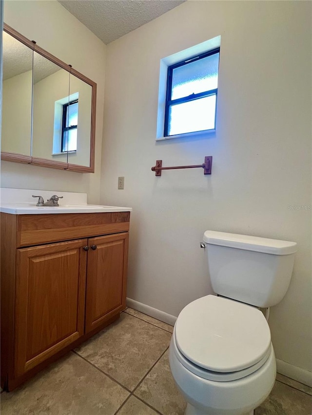 half bathroom featuring toilet, baseboards, and a textured ceiling